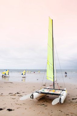 Brittany 'de kumlu bir sahilde yelkenli sürüyor.