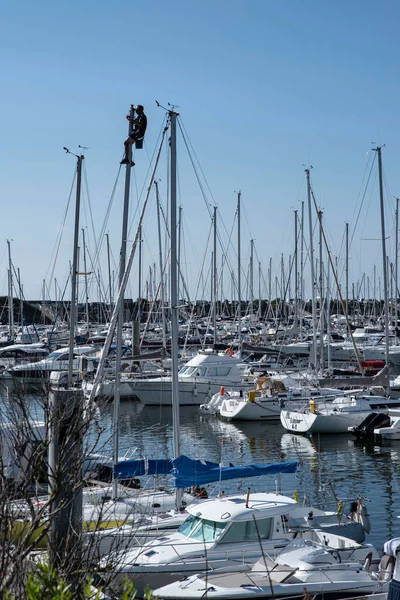 Een Man Bovenop Een Zeilboot Mast Repareert Een Haven — Stockfoto