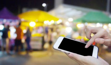 Cep telefonu dokunmatik ekran ile bulanıklık gece Pazar kullanan kadın