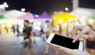 Cep telefonu dokunmatik ekran ile bulanıklık gece Pazar kullanan kadın