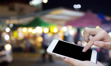 Cep telefonu dokunmatik ekran ile bulanıklık gece Pazar kullanan kadın