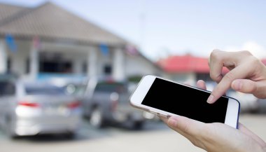 Cep telefonu dokunmatik ekran ile bulanıklık arabalar Park kullanan kadın