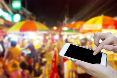 Cep telefonu dokunmatik ekran ile bulanıklık gece Pazar kullanan kadın