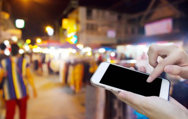 Cep telefonu dokunmatik ekran ile bulanıklık gece Pazar kullanan kadın