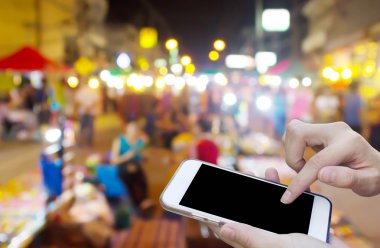 Cep telefonu dokunmatik ekran ile bulanıklık gece Pazar kullanan kadın