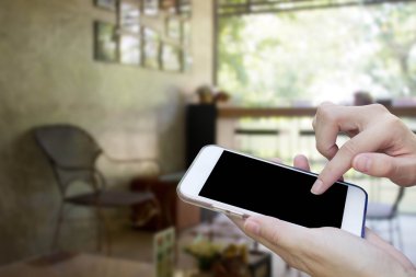 Cep telefonu dokunmatik ekran ile kahve dükkanı bulanıklık geri kullanan kadın