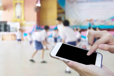 Kadın öğrenci playi bulanıklık ile cep telefonu dokunmatik ekran kullanma