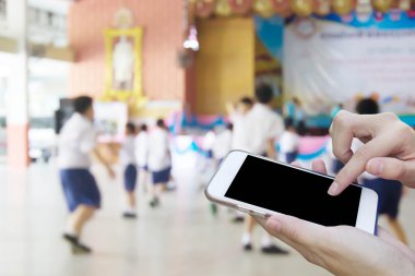 Kadın öğrenci playi bulanıklık ile cep telefonu dokunmatik ekran kullanma