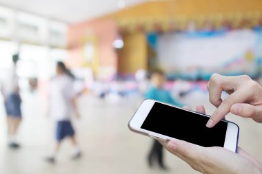 Kadın öğrenci playi bulanıklık ile cep telefonu dokunmatik ekran kullanma