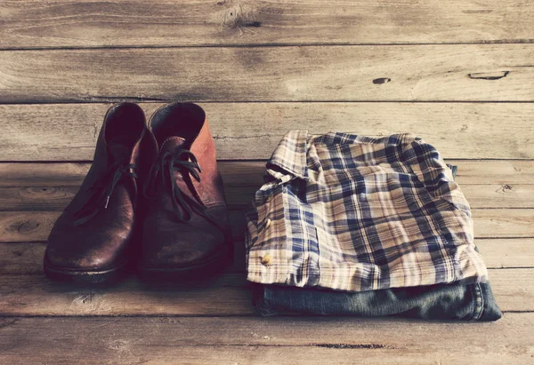 Παλιάς χρονολογίας, καρό πουκάμισο, Jean και δερμάτινα παπούτσια σε φόντο ξύλου — Φωτογραφία Αρχείου