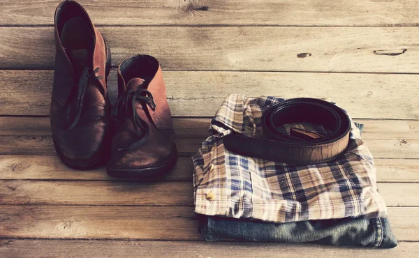 Παλιάς χρονολογίας, καρό πουκάμισο, Jean, με ζώνη, δερμάτινα υποδήματα σε φόντο ξύλου — Φωτογραφία Αρχείου