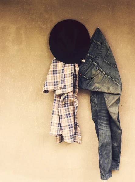 Vintage, kariertes Hemd, Hut, Jeans auf Wandhintergrund — Stockfoto