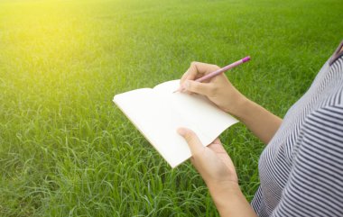 Kalem ve defter mısır tarlası arka plan ile elinde