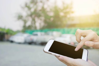 Cep telefonu dokunmatik ekran ile bulanıklık arabalar Park kullanan kadın