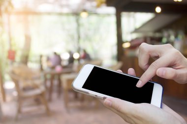 Cep telefonu dokunmatik ekran ile kahve dükkanı bulanıklık geri kullanan kadın