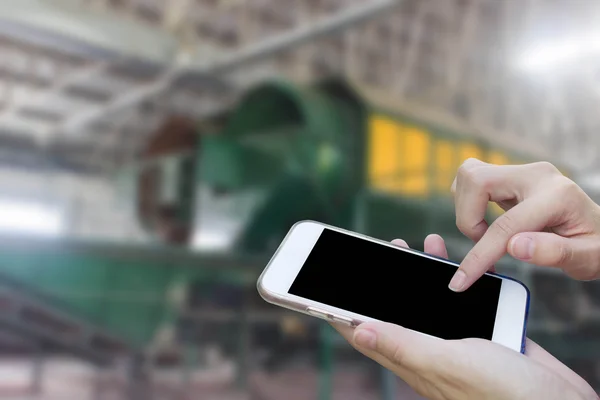 Mujer que usa el teléfono móvil de pantalla táctil con basura de fábrica antigua, W — Foto de Stock