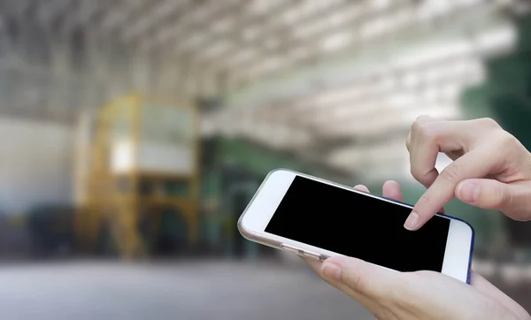 Mujer que usa el teléfono móvil de pantalla táctil con basura de fábrica antigua, W — Foto de Stock