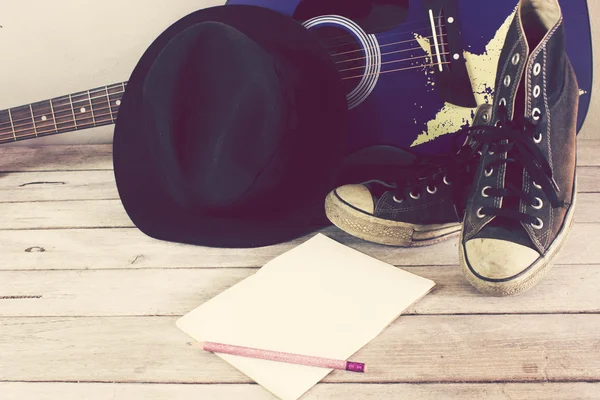 Tom vintage: guitarra, chapéu, tênis, livro, lápis sobre mesa de madeira — Fotografia de Stock