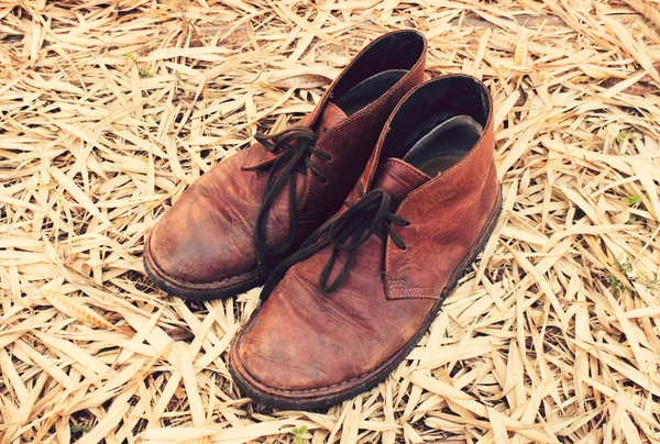 Tom vintage: Sapato de couro em folhas de bambu seco — Fotografia de Stock