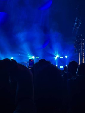 Sahnenin önünde bir rock konserinin dikey çekimi. Bir müzik gösterisinde eğlence. Bir müzik resitalinde hayranlar bir rock grubuna tezahürat yapıyor.