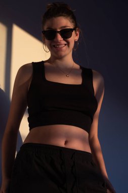 Akşam güneşi altında özgürlük ve pozitifliği ifade eden genç bir kadın markalaşma ve gençlik pazarlaması için mükemmel..