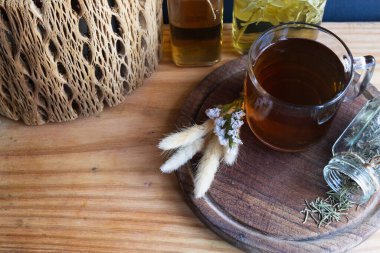 Kırsal ahşap tepside sıcak bitki çayı, içinde doğal malzemeler, kurutulmuş biberiye ve çeşitli botanik aşılar var, sağlık ve bütünsel bakımı destekliyor. Boşluğu kopyala