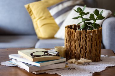 Yeşim bitki crassula ovata eşsiz bir rustik ahşap demlik büyüyen, doğal ev dekorasyonu ve koni bir dokunuş ekleyerek, çam kozalakları ve bir dantel altlık üzerinde yanan bir mum. İç tasarım dekorasyonları için ideal.