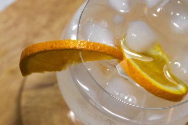 Buzlu ve portakal dilimli cin tonik kokteyli. Yaz partileri için mükemmel. Barda içki içmek ya da sıcak bir günde serin bir şeyler içmek.