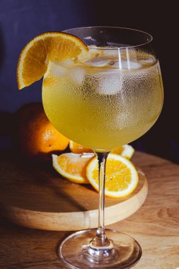 Taze portakallı cin tonik kokteyli ve büyük bardakta buz. Yaz partileri ve indirimli içki saati için mükemmel. Dramatik ışık. Bar promosyonları için ideal.