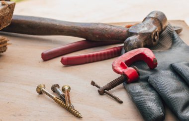 Çekiç, klemp, pense ve ahşap tezgah vidaları gibi çeşitli inşaat aletleri. Ev bakımı ve profesyonel işler için alet ve ekipmanlar.