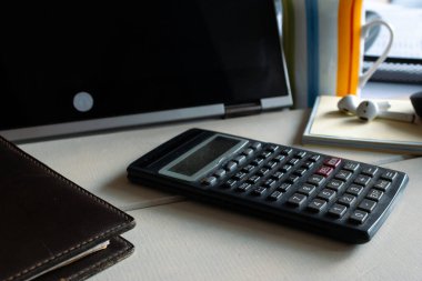 Dizüstü bilgisayarı, bilimsel hesap makinesi, günlük ve kablosuz kulaklıkları olan ofis masası, modern uzaktan kumandalı çalışmalar, serbest çalışmalar, finans planlaması ve profesyoneller için temel çalışmalar