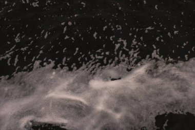 Nehirdeki bir teknenin köpük izi.