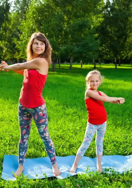 Mãe e sua filha ao ar livre fazendo ioga — Fotografia de Stock