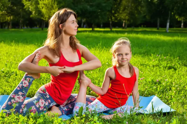 Mor och hennes dotter utomhus gör yoga — Stockfoto