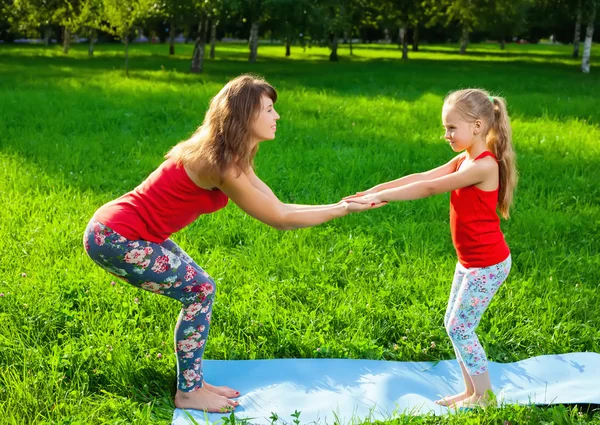 Madre y su hija al aire libre haciendo yoga — Foto de Stock