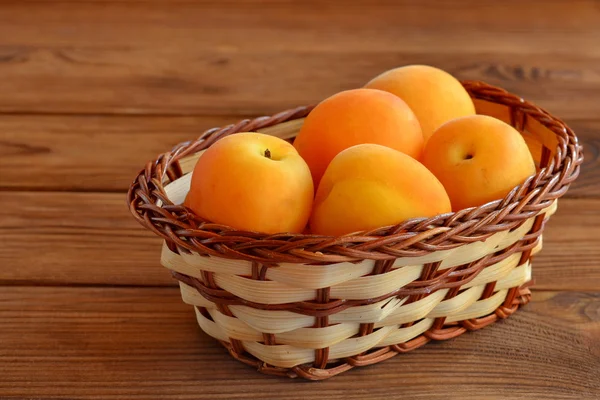 Ripe bright apricots in beige basket — Stock Photo, Image