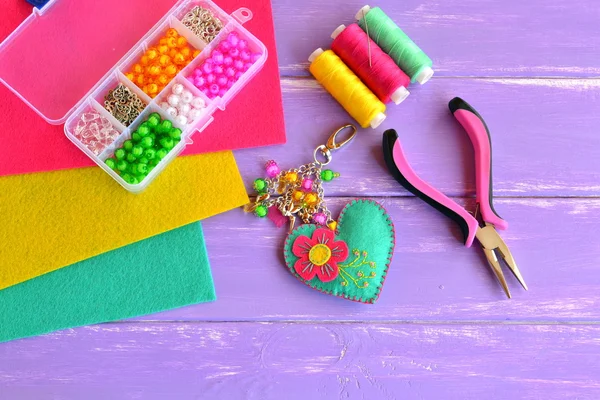 Bright handmade heart keychain with flower, beads. Felt, thread, pliers, needle, box, beads, pendants. Felt keychain suppliers. Set to create beautiful crafts. Love heart key ring. Felt heart ornament — Stock Photo, Image