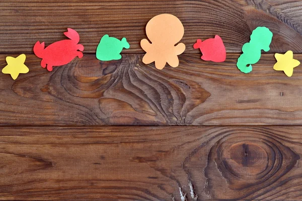 Wooden background with colorful paper sea animals. Paper sea creatures art projects — Foto de Stock