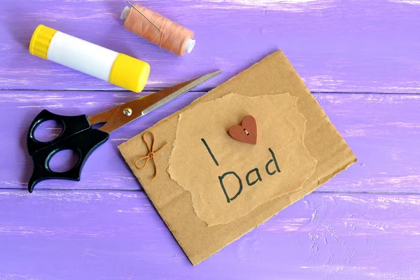 아버지 날이나 생일 인사 카드 문자로 아빠를 사랑해요. 손으로 만든 아버지들의 카드 선물. 가위, 접착제, 실. 재활용 된 포켓 뗏목의 영감. 아이들을 위한 종이 창조적 아이디어 재활용 — 스톡 사진