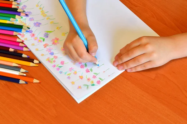 Barnet håller en penna i handen och ritar en äng med blommor. Barn färga kritor. Kreativ konstutbildning för barn. Dagis blommig ritning lektion. Kid rita blomma collage med krita — Stockfoto