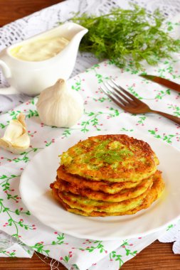 Sarımsak ve dereotu bir plaka üzerinde kabak börek. Yeşil dereotu, sarımsak, çatal, bıçak, bir tablo teknede sos. Aile için kolay ve lezzetli bir yemek fikir. Yakın çekim