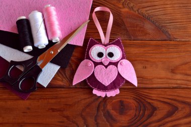 Keçe baykuş süslemesi. Keçe baykuş oyuncak. Çocuklar Diy el sanatları. Renkli keçe, makas, iplik, iğne, ahşap masa levhalar