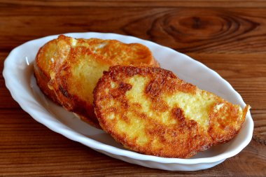 Fried kruton. Kızarmış ekmek dilimleri kahverengi ahşap masa üzerinde bir tabakta. Çocuklar yemek fikri. Lezzetli aperatif. Portre