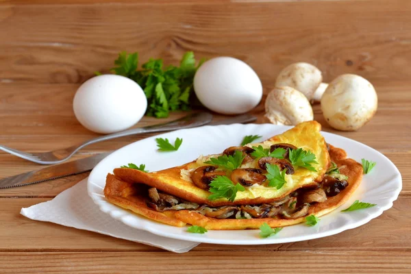 Kitschiges Pilz-Omelett. Omelette mit gebratenen Pilzen, Käse und Petersilie. Frühstücksei-Rezept. hölzerner Hintergrund. — Stockfoto