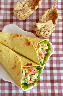 Doldurulmuş Mısır, yumurta, yengeç eti, pide yaprak marul. Pide üzerinde beyaz bir tabak salata