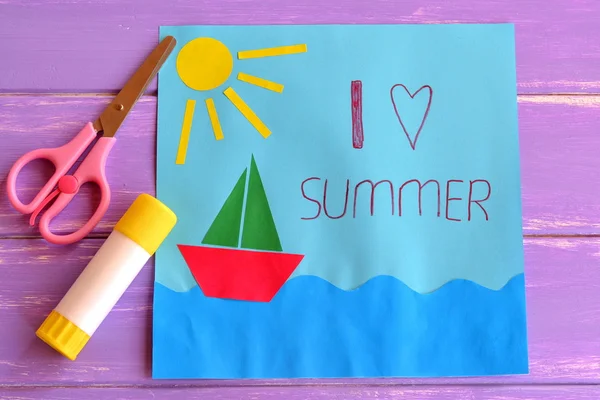 Colorful paper card with ship, sea, sun and words I love summer. Scissors and glue stick on lilac wooden background. Preschool and kindergarten paper crafts. Summer fun background. — Stock Photo, Image