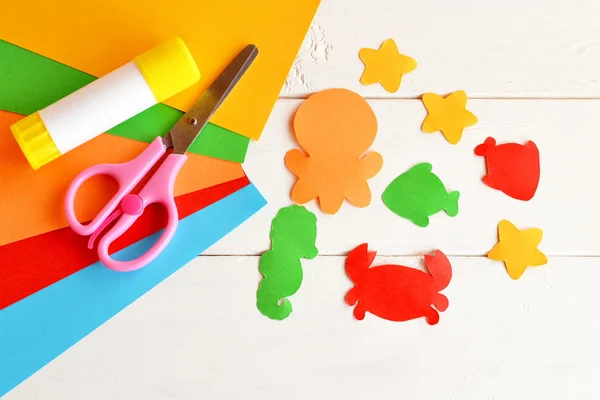 Sheets of colored paper, scissors, glue, paper fish and sea creatures. DIY concept. Kids craft idea — Stock Photo, Image