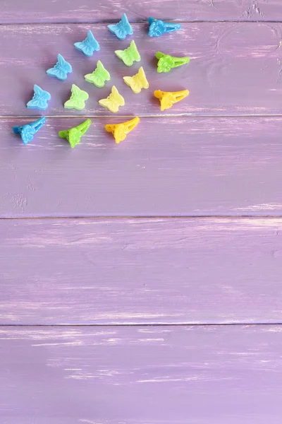 Kit de pinces à cheveux colorées pour les filles sur fond en bois lilas avec espace de copie pour le texte. Photo verticale. Vue du dessus — Photo