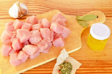 Çiğ et parçalar Ahşap mutfak masa, sarımsak, baharatlar, zeytin yağı, Kuru defne yaprağı üzerinde yığını