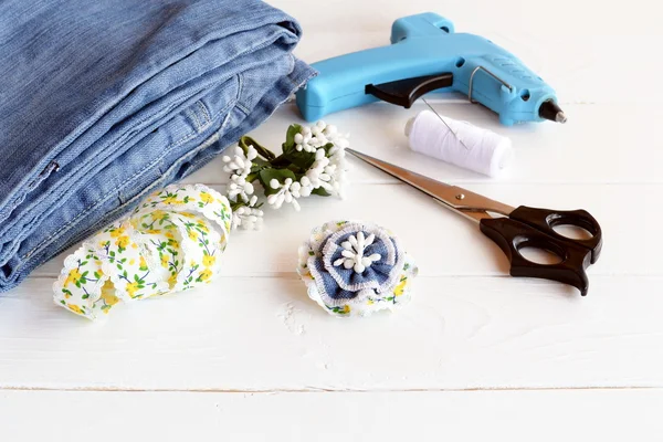 Şık Çiçek Broş kullanarak eski kot geri dönüştürülmüş. DIY ev yapımı kot aksesuar. Makas, yapıştırıcı silah, dantel, Tel, iğne, ahşap bir masa mavi kot